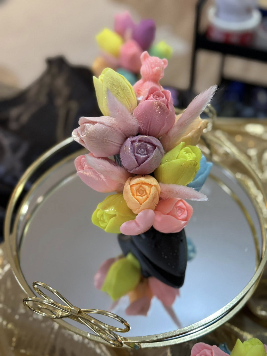 Малък букет от сапунени цветя с розови, лилави и зелени розички върху златен обръч