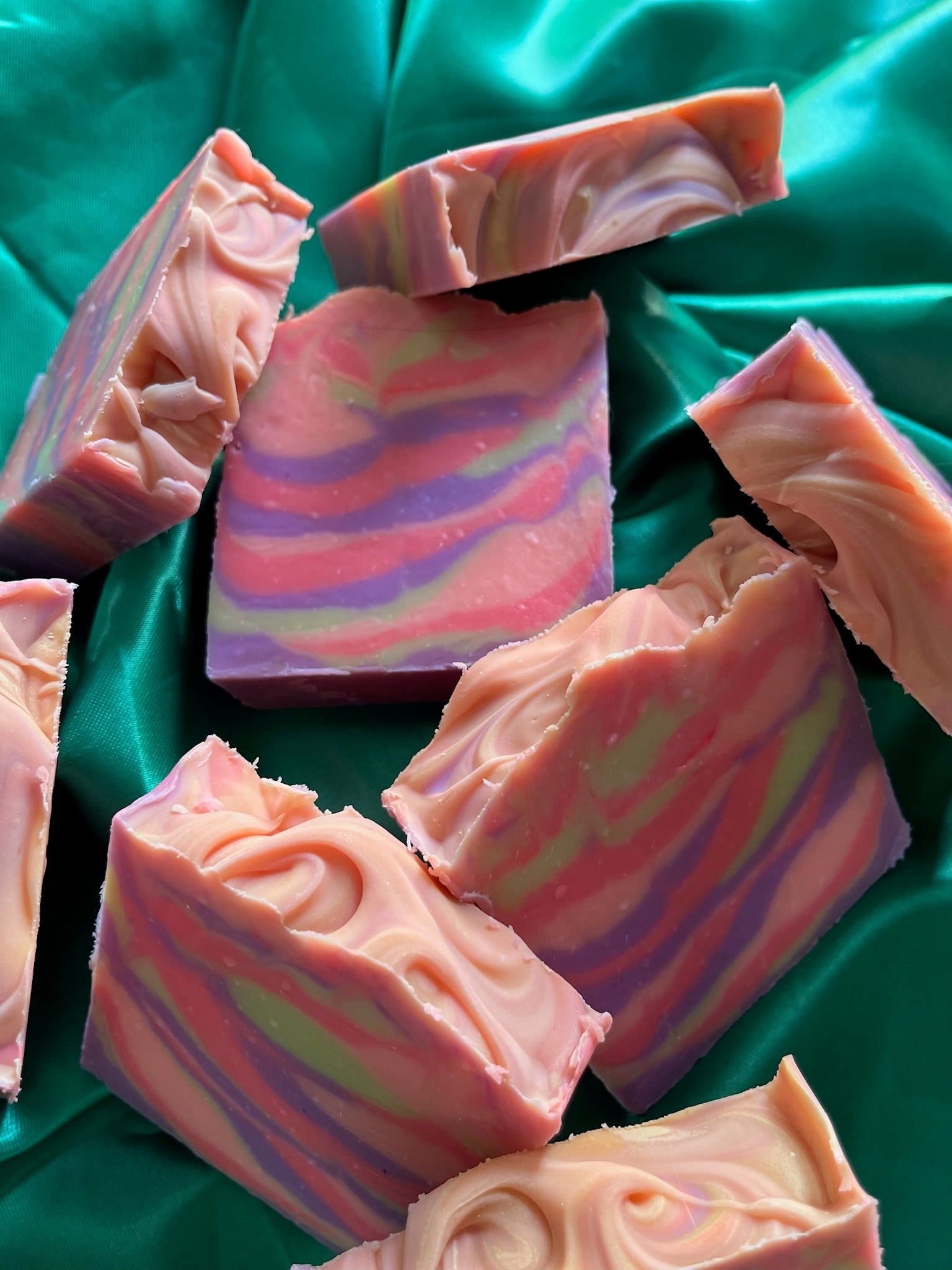 Handmade luxury soap bars with pink, purple, and yellow swirl layers