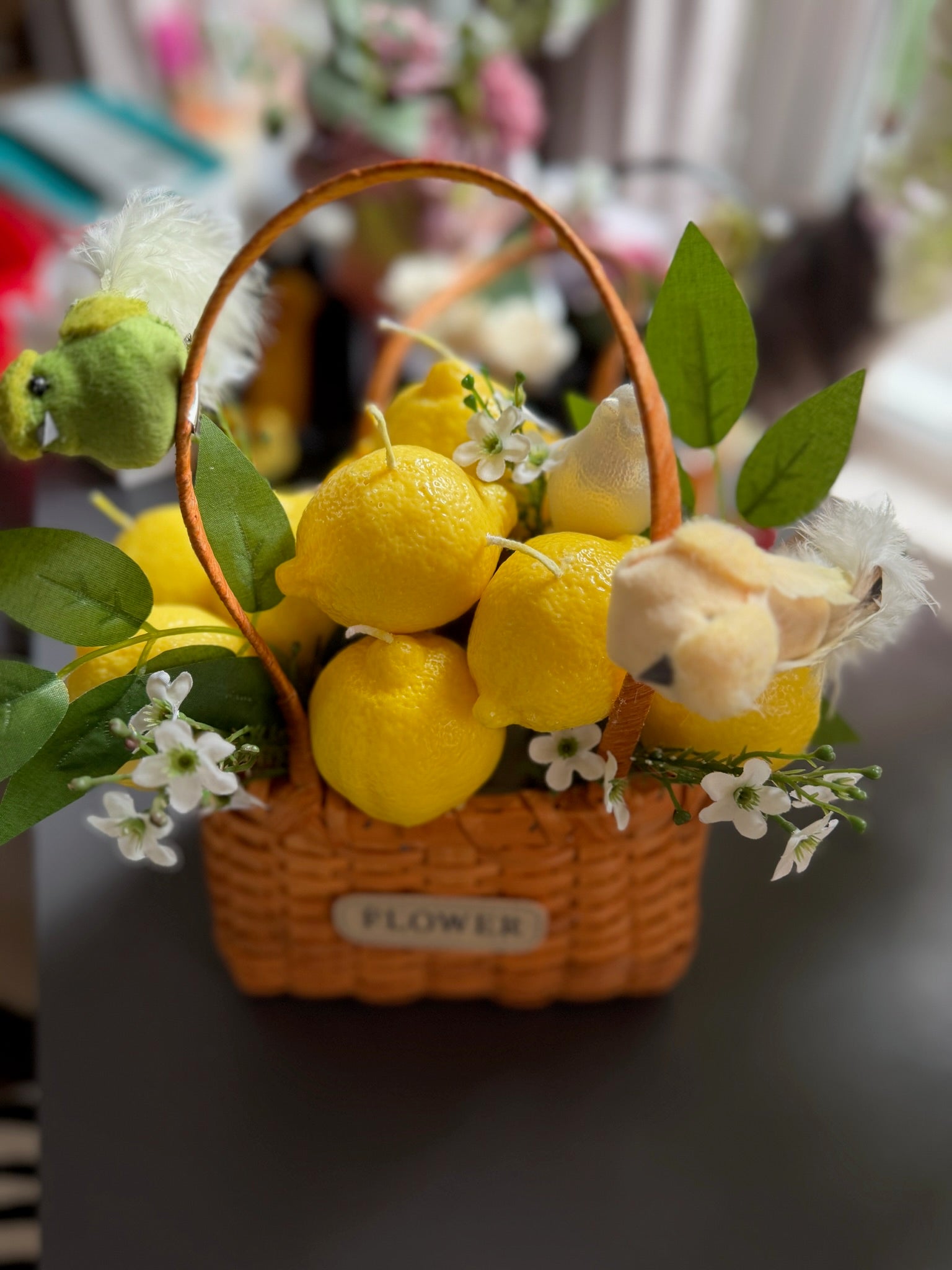 Кошик з лимонами та квітами: плетений кошик, жовті лимони, напис FLOWER на бирці