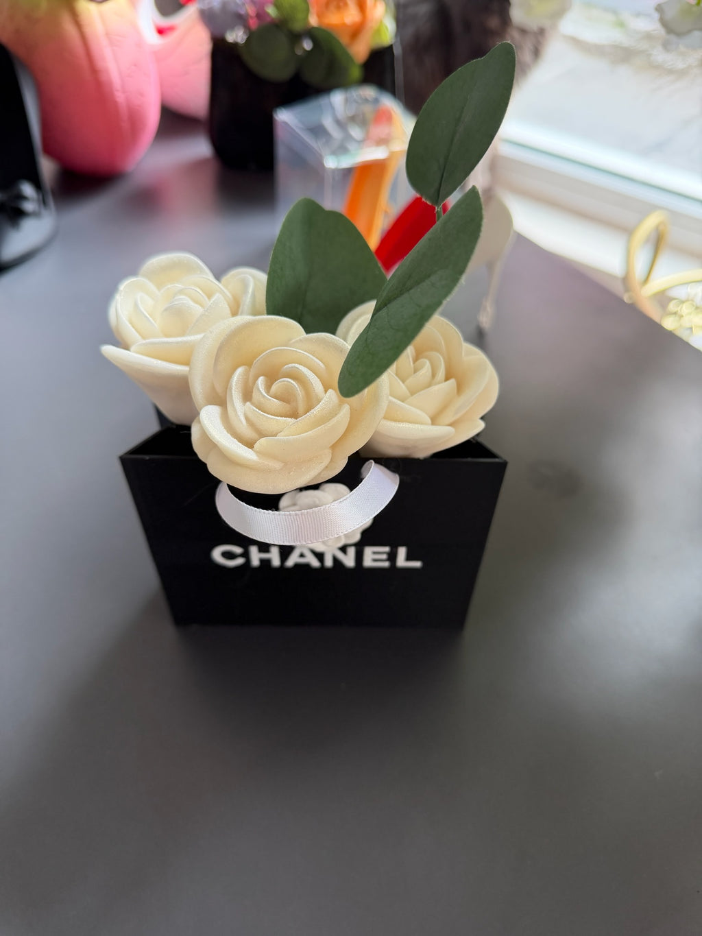3D букет с кремави рози и зелени листа в черна чантичка с надпис CHANEL