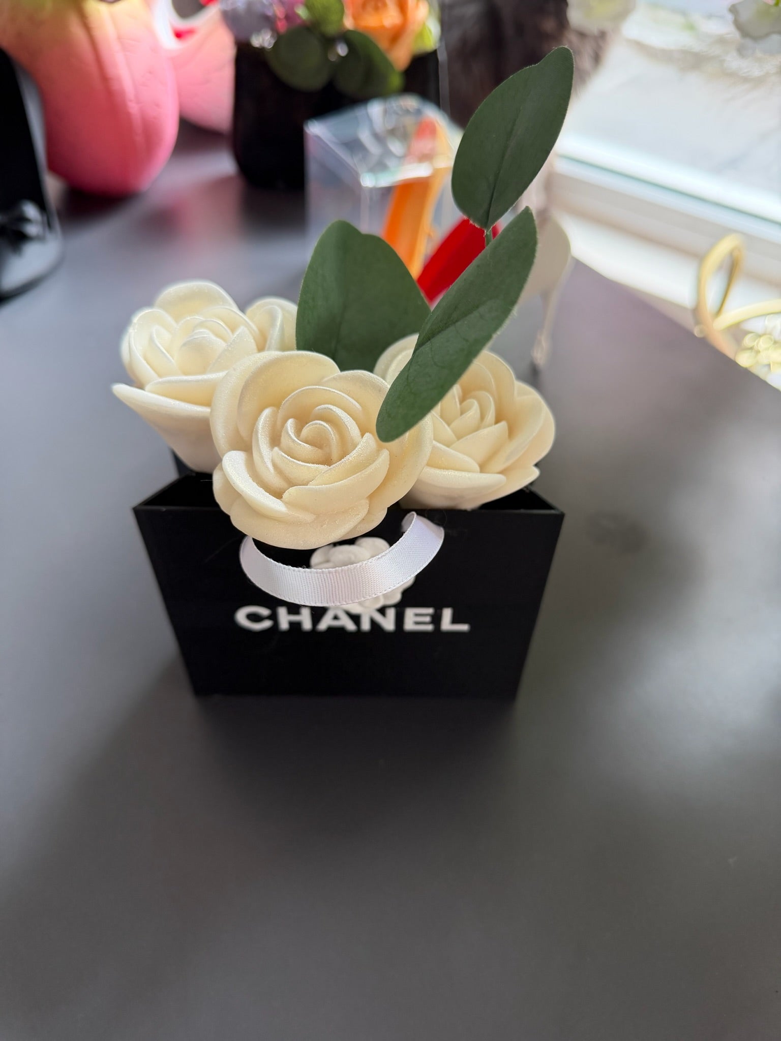 3D букет с кремави рози и зелени листа в черна чантичка с надпис CHANEL