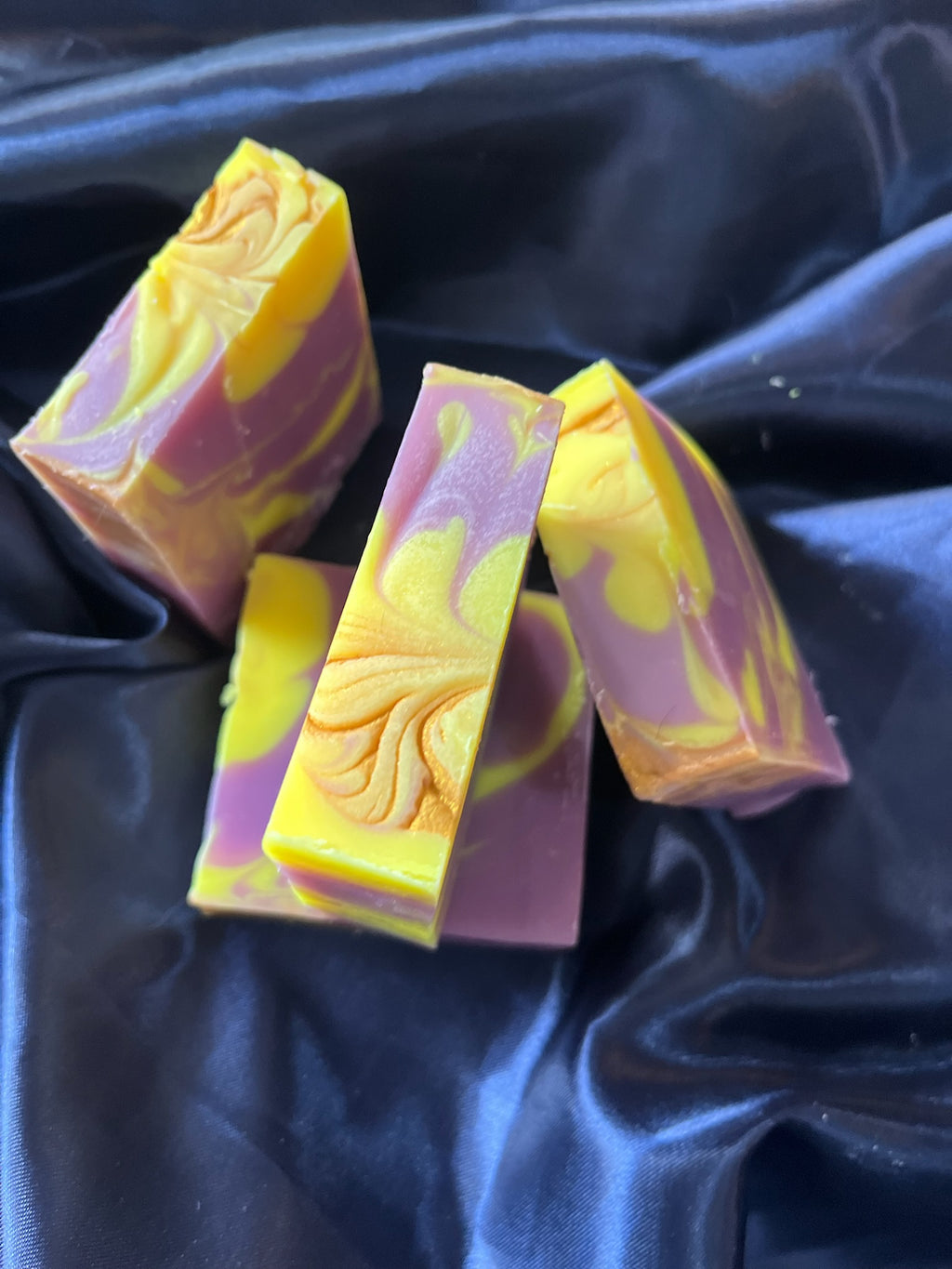 Soap bar assortment with purple and yellow swirls, floral carved embossing on one bar