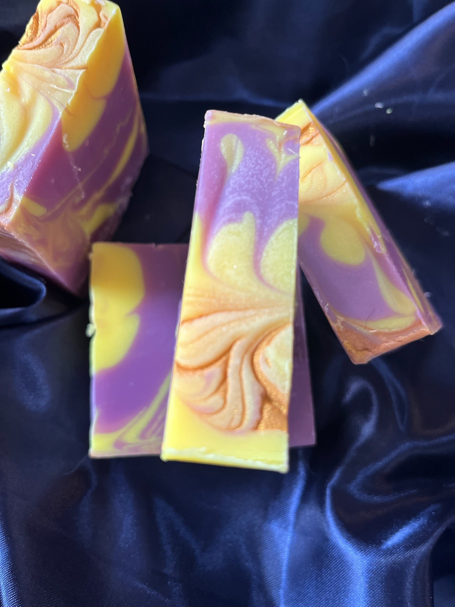 Purple and yellow marbled soap bars with embossed swirl on the front bar face