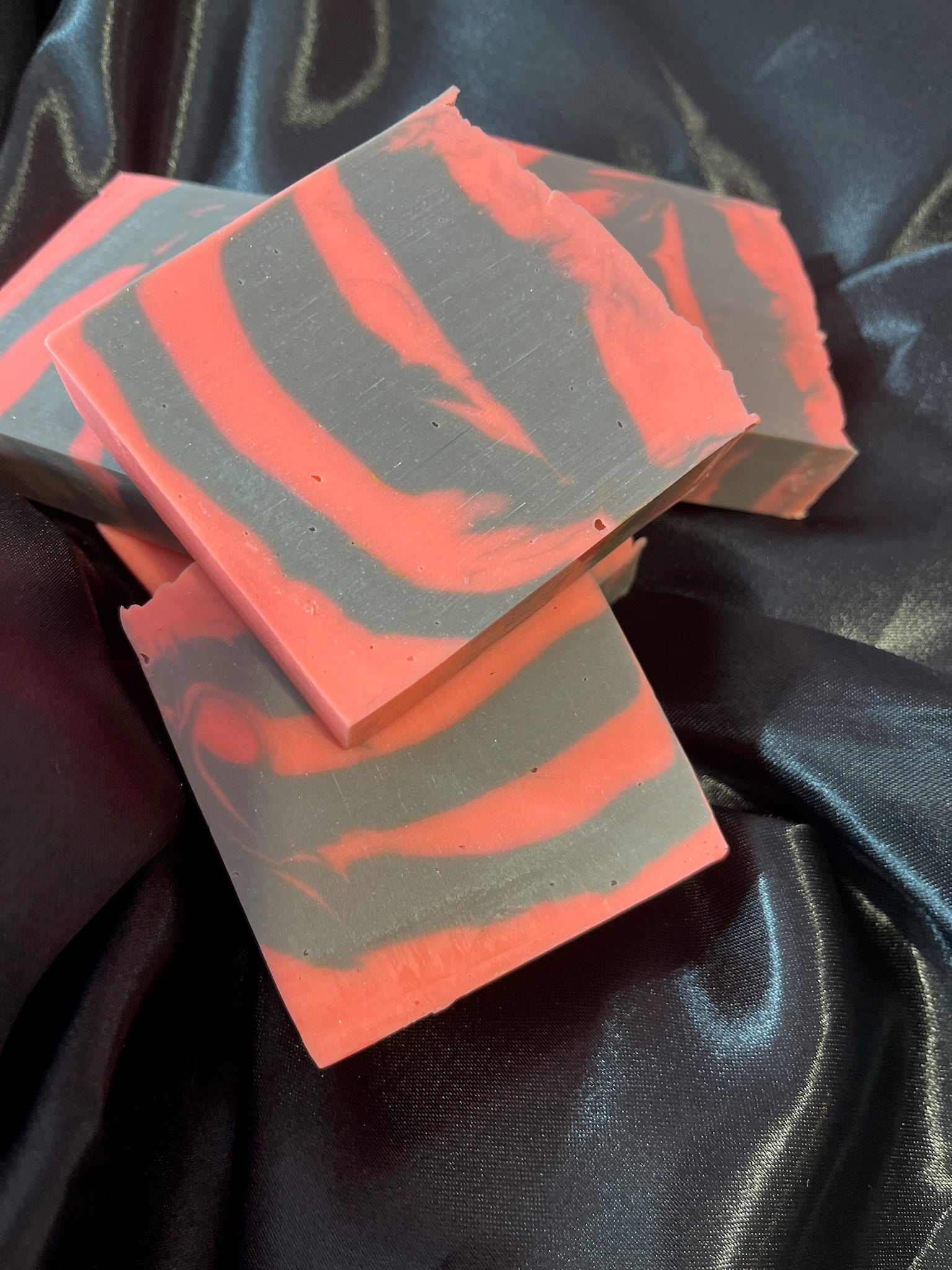 Layered coral and gray striped soap bars in a neat stack